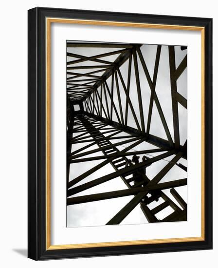 A Reenactor is Silhouetted Inside a Replica of the Spindletop Oil Derrick-null-Framed Photographic Print