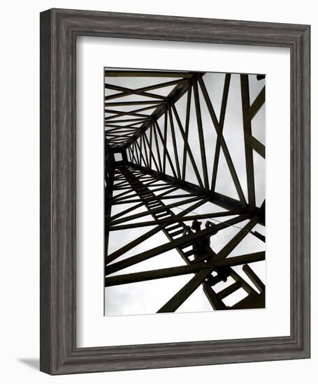 A Reenactor is Silhouetted Inside a Replica of the Spindletop Oil Derrick-null-Framed Photographic Print