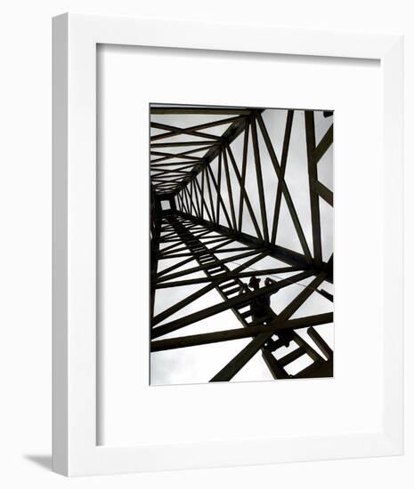 A Reenactor is Silhouetted Inside a Replica of the Spindletop Oil Derrick-null-Framed Photographic Print