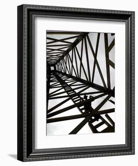 A Reenactor is Silhouetted Inside a Replica of the Spindletop Oil Derrick-null-Framed Photographic Print