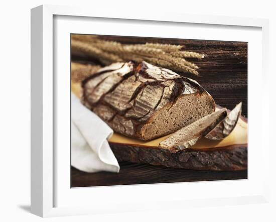 A Rustic Country Loaf on a Slice of Wood-Karl Newedel-Framed Photographic Print