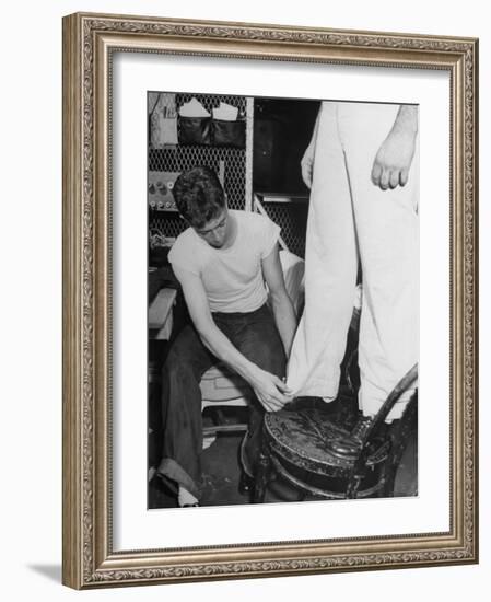 A Sailor in the Tailor Shop Aboard a US Navy Cruiser Checking Uniform Trousers of Another Sailor-null-Framed Photographic Print