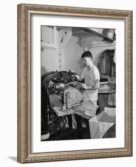 A Sailor Pressing Uniform Trousers in the Tailor Shop of a US Navy Cruiser-null-Framed Photographic Print