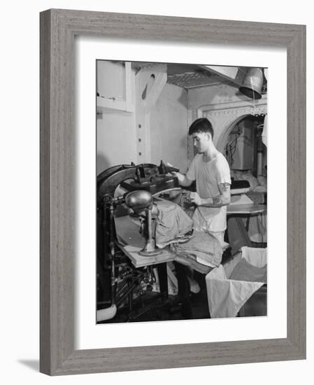 A Sailor Pressing Uniform Trousers in the Tailor Shop of a US Navy Cruiser-null-Framed Photographic Print