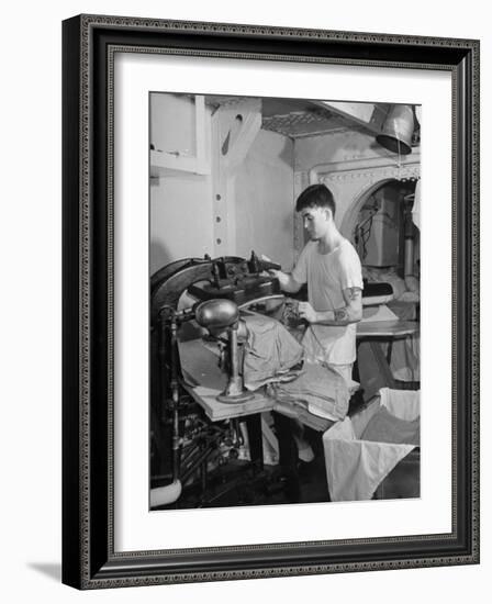 A Sailor Pressing Uniform Trousers in the Tailor Shop of a US Navy Cruiser-null-Framed Photographic Print