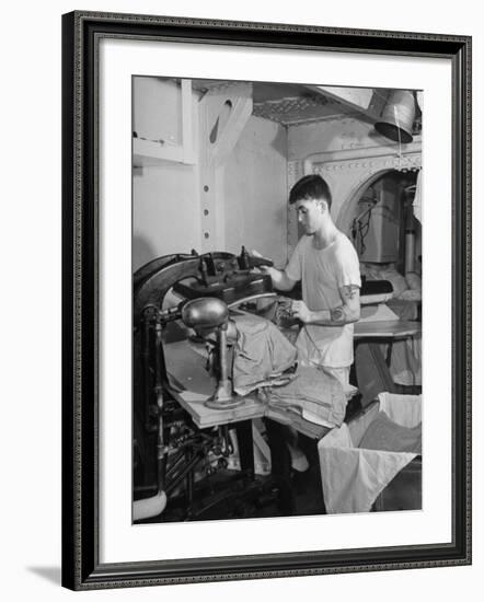 A Sailor Pressing Uniform Trousers in the Tailor Shop of a US Navy Cruiser-null-Framed Photographic Print