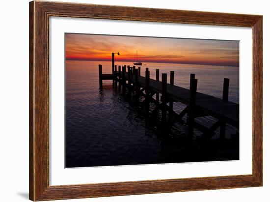 A Single Sailboat Sits on the Water of the Bay Alongside an Empty Dock on Tilghman Island, Maryland-Karine Aigner-Framed Photographic Print