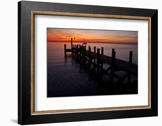 A Single Sailboat Sits on the Water of the Bay Alongside an Empty Dock on Tilghman Island, Maryland-Karine Aigner-Framed Photographic Print