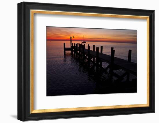 A Single Sailboat Sits on the Water of the Bay Alongside an Empty Dock on Tilghman Island, Maryland-Karine Aigner-Framed Photographic Print