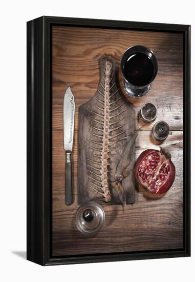 A Still Life Featuring a Fish Skeleton, Pomegranate and Red Wine-Komar-Framed Premier Image Canvas