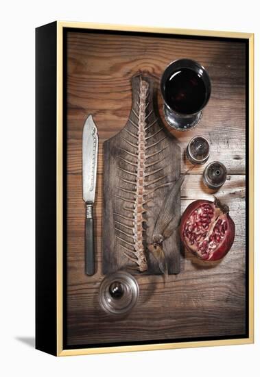 A Still Life Featuring a Fish Skeleton, Pomegranate and Red Wine-Komar-Framed Premier Image Canvas