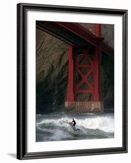 A Surfer is Dwarfed by the Northern End of the Golden Gate Bridge While Riding the Waves-null-Framed Photographic Print