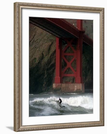 A Surfer is Dwarfed by the Northern End of the Golden Gate Bridge While Riding the Waves-null-Framed Photographic Print