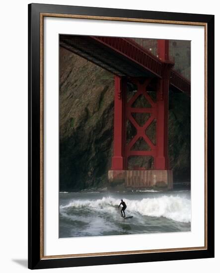 A Surfer is Dwarfed by the Northern End of the Golden Gate Bridge While Riding the Waves-null-Framed Photographic Print