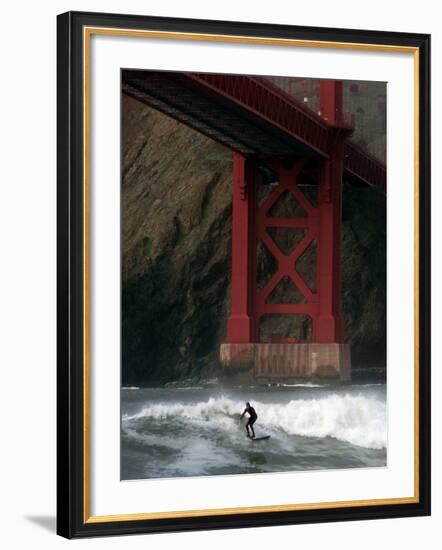 A Surfer is Dwarfed by the Northern End of the Golden Gate Bridge While Riding the Waves-null-Framed Photographic Print