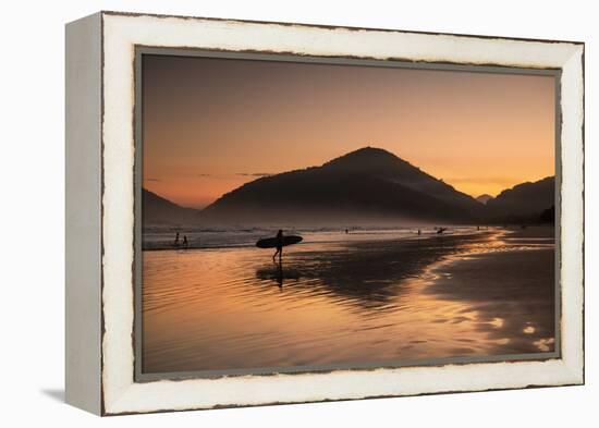 A Surfer Makes His Way Out of the Water at Sunset on Praia Do Itamambuca in Brazil-Alex Saberi-Framed Premier Image Canvas