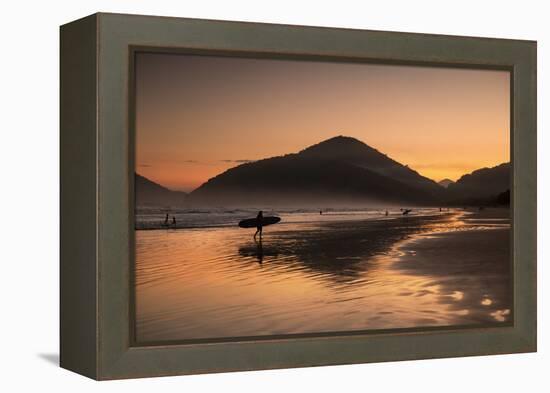 A Surfer Makes His Way Out of the Water at Sunset on Praia Do Itamambuca in Brazil-Alex Saberi-Framed Premier Image Canvas