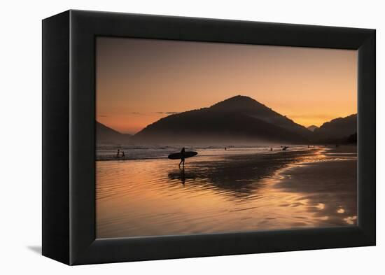 A Surfer Makes His Way Out of the Water at Sunset on Praia Do Itamambuca in Brazil-Alex Saberi-Framed Premier Image Canvas