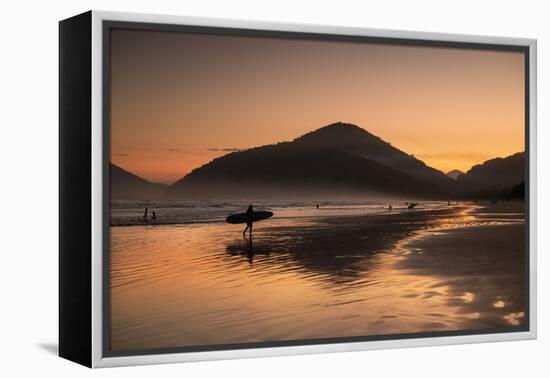 A Surfer Makes His Way Out of the Water at Sunset on Praia Do Itamambuca in Brazil-Alex Saberi-Framed Premier Image Canvas
