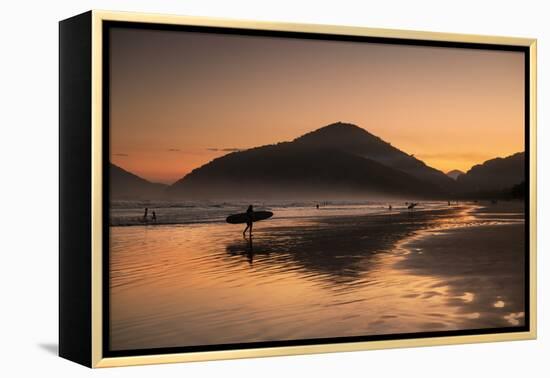 A Surfer Makes His Way Out of the Water at Sunset on Praia Do Itamambuca in Brazil-Alex Saberi-Framed Premier Image Canvas