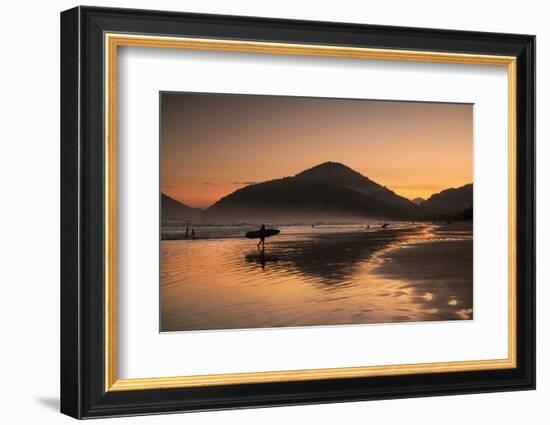 A Surfer Makes His Way Out of the Water at Sunset on Praia Do Itamambuca in Brazil-Alex Saberi-Framed Photographic Print