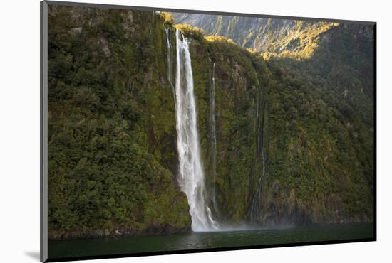 A Tall Waterfall Drops Off a Steep Cliff into Waters, Milford Sound on South Island, New Zealand-Paul Dymond-Mounted Photographic Print