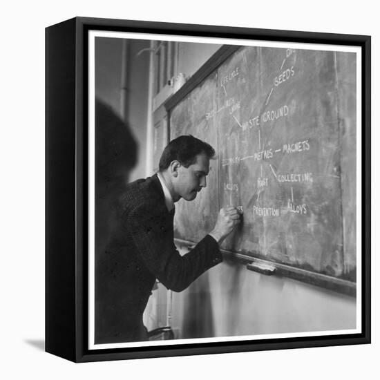 A Teacher Writing on a Blackboard at Northfield House Junior School, Leicester-Henry Grant-Framed Premier Image Canvas