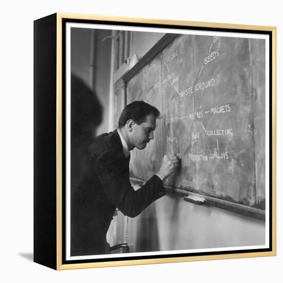 A Teacher Writing on a Blackboard at Northfield House Junior School, Leicester-Henry Grant-Framed Premier Image Canvas