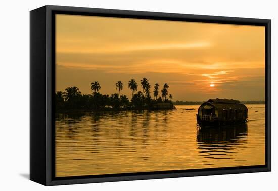 A traditional houseboat moves past the setting sun on the Kerala Backwaters, Kerala, India, Asia-Logan Brown-Framed Premier Image Canvas