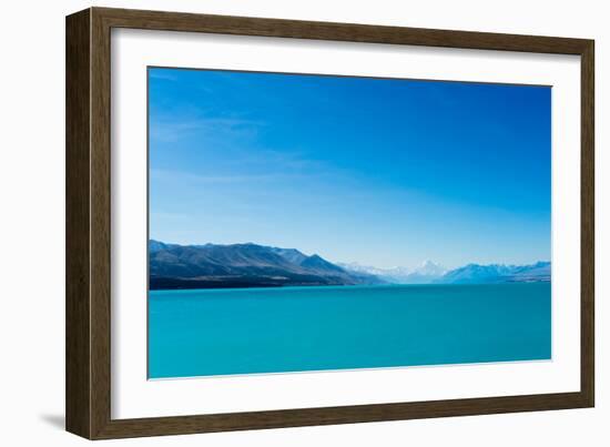 A turquoise blue lake with snow covered mountains in the distance, South Island, New Zealand-Logan Brown-Framed Photographic Print