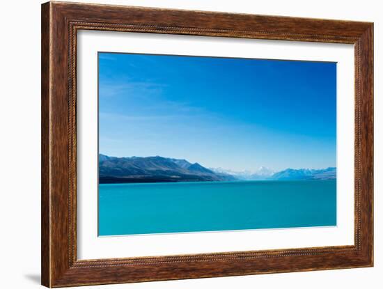 A turquoise blue lake with snow covered mountains in the distance, South Island, New Zealand-Logan Brown-Framed Photographic Print