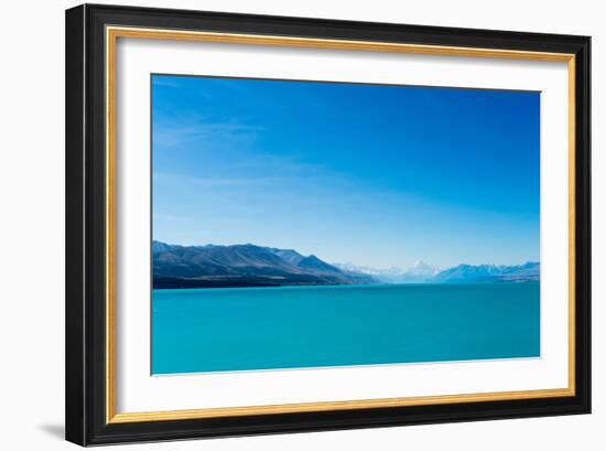 A turquoise blue lake with snow covered mountains in the distance, South Island, New Zealand-Logan Brown-Framed Photographic Print