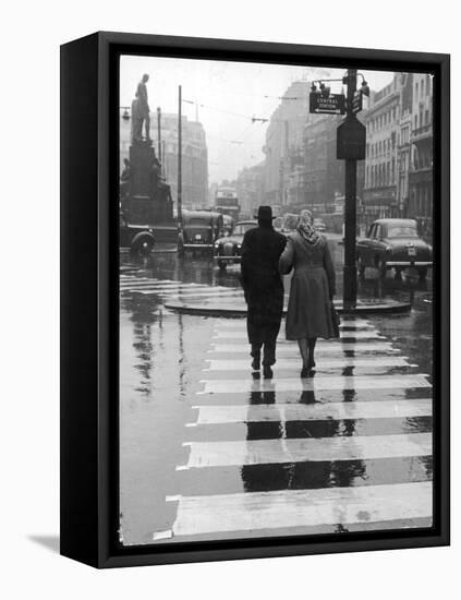 A Typical English Street on a Rainy Shopping Day: an Elderly Couple Use the Zebra Crossing-Henry Grant-Framed Premier Image Canvas