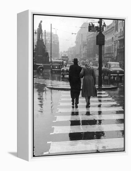 A Typical English Street on a Rainy Shopping Day: an Elderly Couple Use the Zebra Crossing-Henry Grant-Framed Premier Image Canvas