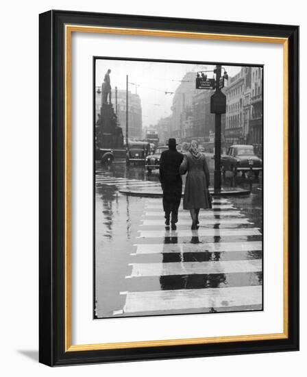 A Typical English Street on a Rainy Shopping Day: an Elderly Couple Use the Zebra Crossing-Henry Grant-Framed Photographic Print