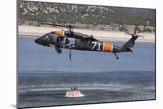 A U.S. Army Uh-60 Black Hawk Helicopter Collects Water from a Reservoir-null-Mounted Photographic Print