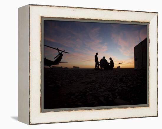 A UH-60 Black Hawk Crew Carry Out a Mission Brief at Sunset-null-Framed Premier Image Canvas