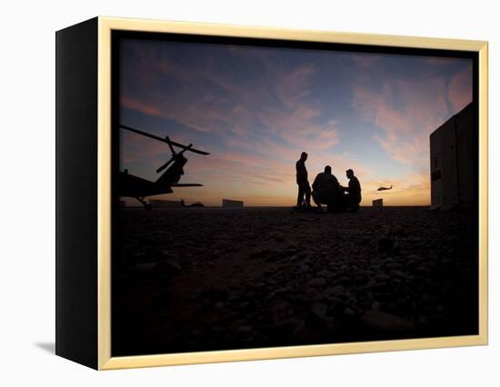 A UH-60 Black Hawk Crew Carry Out a Mission Brief at Sunset-null-Framed Premier Image Canvas