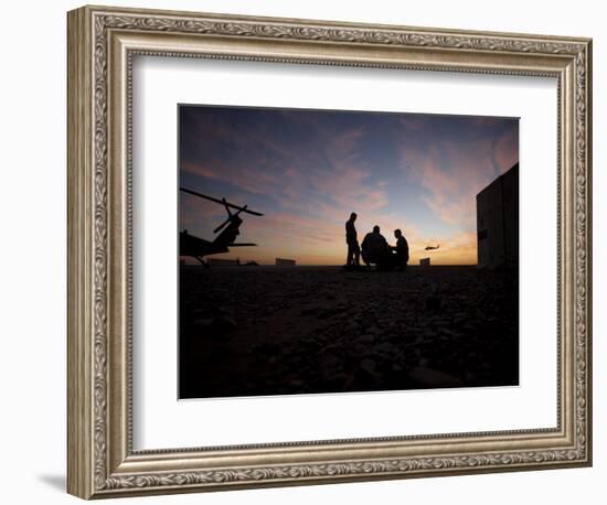 A UH-60 Black Hawk Crew Carry Out a Mission Brief at Sunset-null-Framed Photographic Print