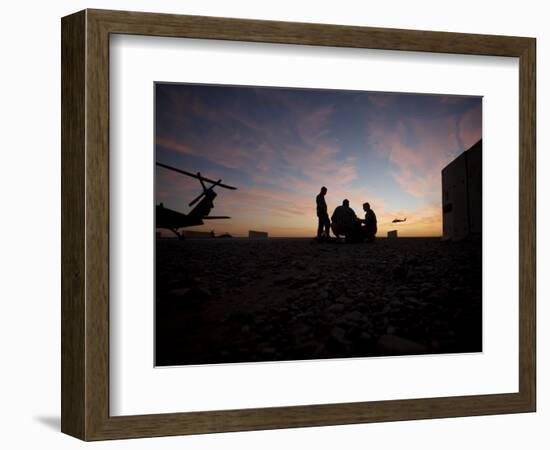 A UH-60 Black Hawk Crew Carry Out a Mission Brief at Sunset-null-Framed Photographic Print