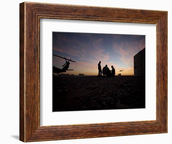 A UH-60 Black Hawk Crew Carry Out a Mission Brief at Sunset-null-Framed Photographic Print