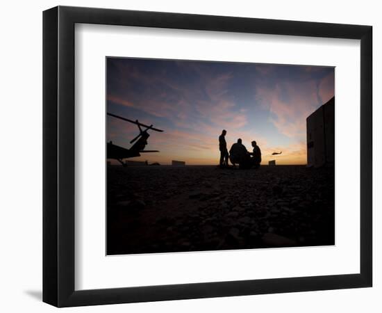 A UH-60 Black Hawk Crew Carry Out a Mission Brief at Sunset-null-Framed Photographic Print