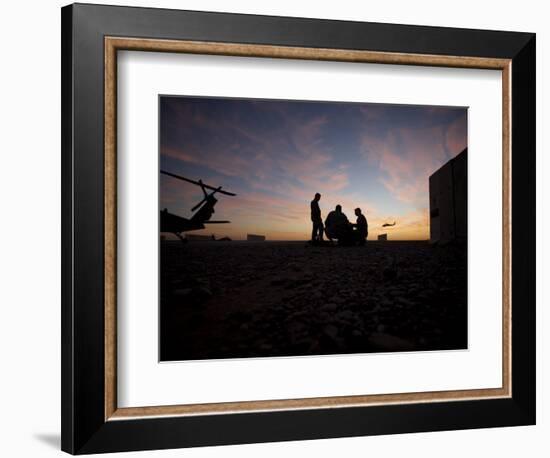 A UH-60 Black Hawk Crew Carry Out a Mission Brief at Sunset-null-Framed Photographic Print