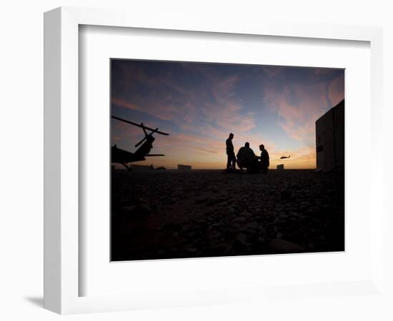 A UH-60 Black Hawk Crew Carry Out a Mission Brief at Sunset-null-Framed Photographic Print