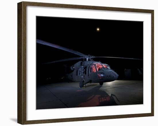 A UH-60 Black Hawk Helicopter Parked on the Flight Line under a Full Moon-null-Framed Photographic Print