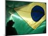 A Vendor Walks Behind a Big Brazilian Flag-null-Mounted Photographic Print