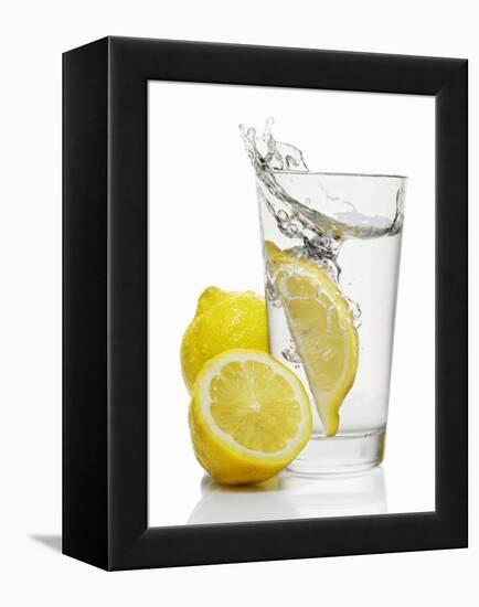 A Wedge of Lemon Falling into a Glass of Water-Kröger & Gross-Framed Premier Image Canvas