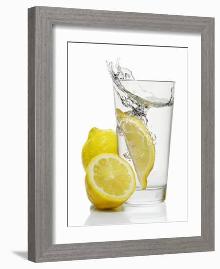 A Wedge of Lemon Falling into a Glass of Water-Kröger & Gross-Framed Photographic Print