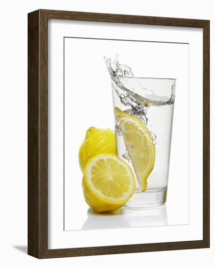 A Wedge of Lemon Falling into a Glass of Water-Kröger & Gross-Framed Photographic Print