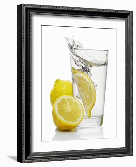 A Wedge of Lemon Falling into a Glass of Water-Kröger & Gross-Framed Photographic Print